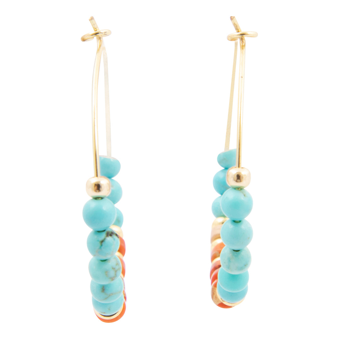 Pair of earrings with turquoise beads and gold accents on a white background
