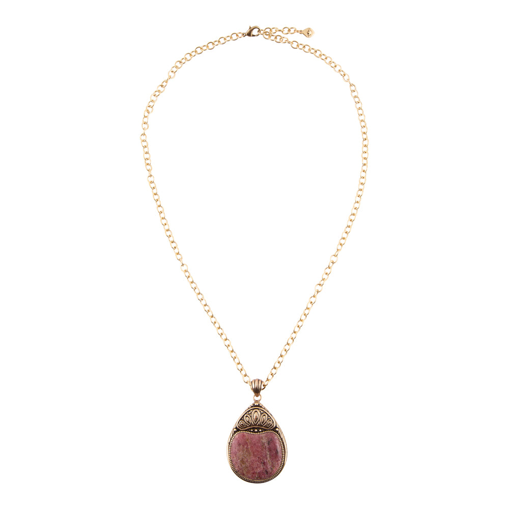 A gold chain necklace with a teardrop-shaped pendant featuring a pinkish-purple stone and ornate gold-toned metal detailing, shown against a plain white background.