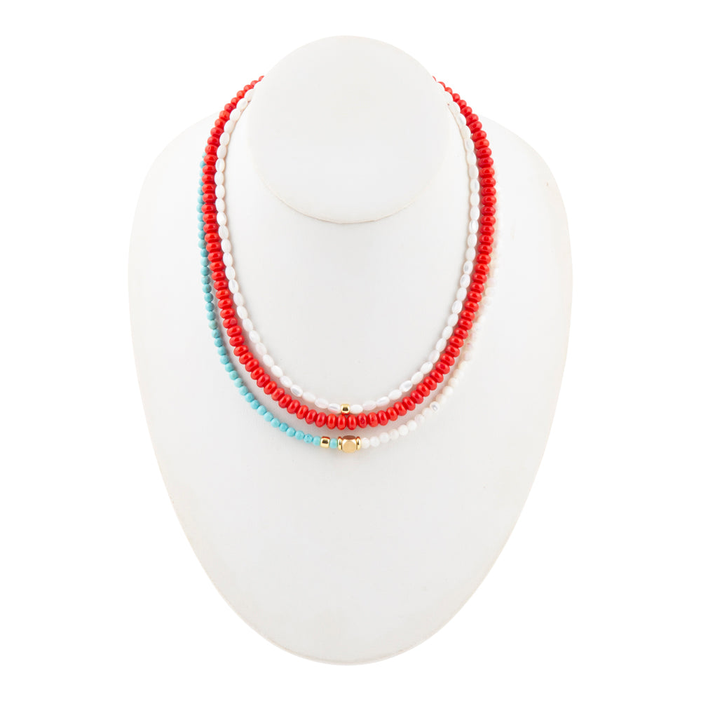 Necklace with red and white beads on a white stand