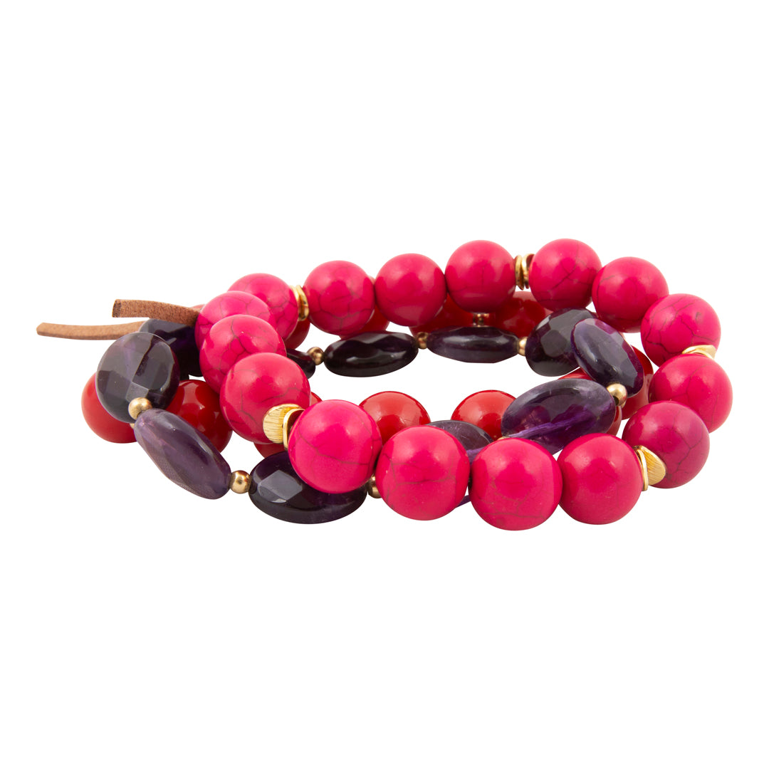 Stack of pink and purple beaded bracelets on a white background