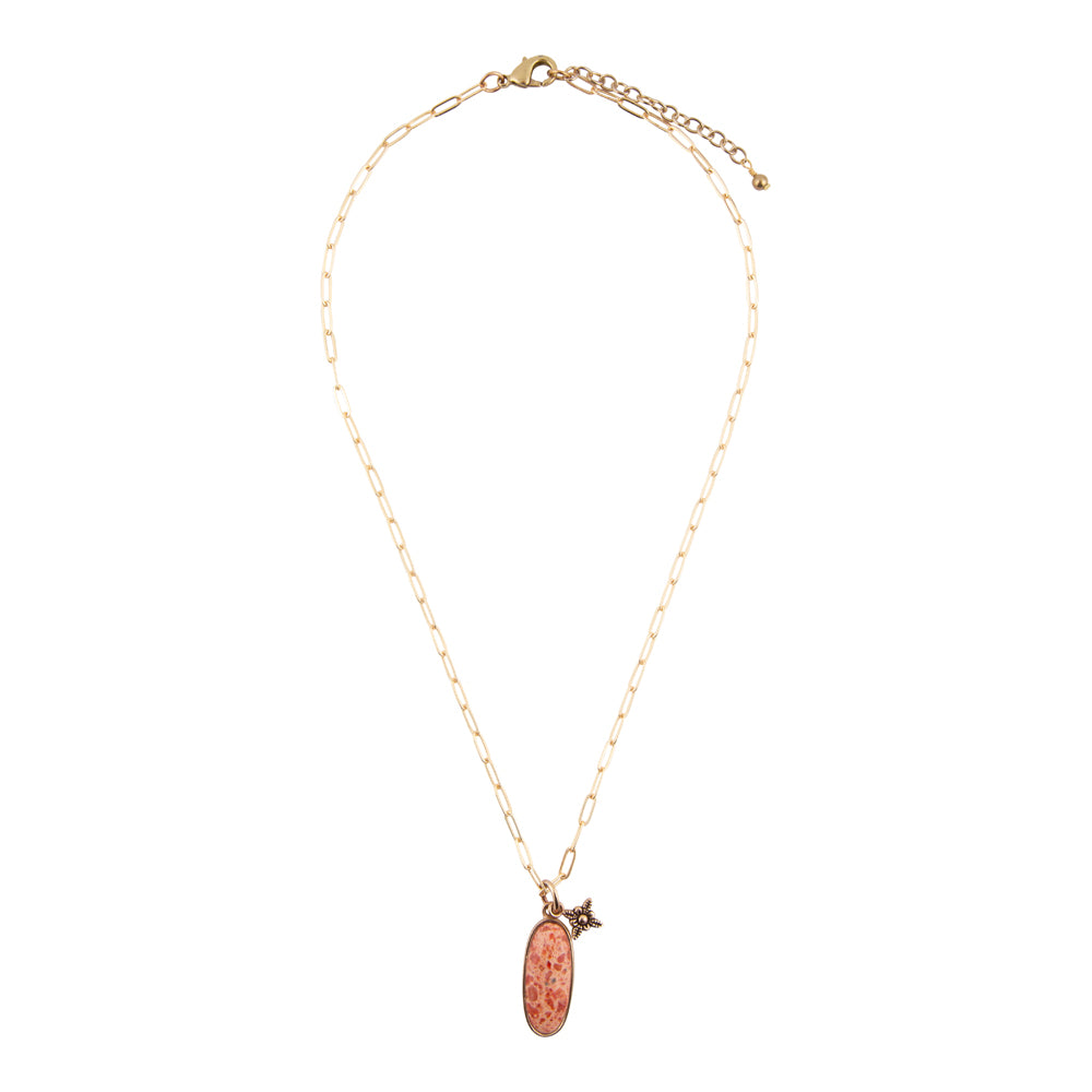 A delicate gold chain necklace featuring an oval copper pendant with a textured pattern and a small gold bird charm, displayed against a solid white background.
