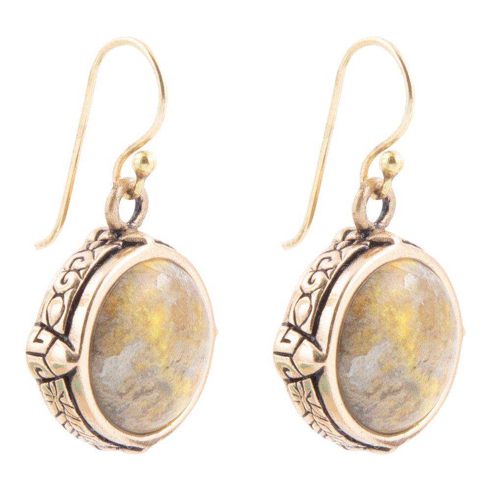 A pair of dangling earrings with oval cabochon stones featuring yellow and gray marbling, set in ornate antiqued gold-tone metal with fishhook wires.