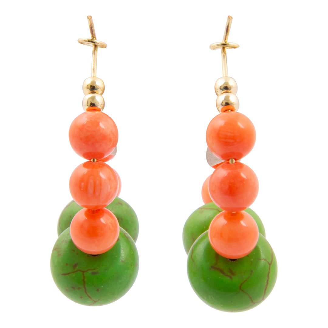 Pair of earrings with green and orange beads on a white background
