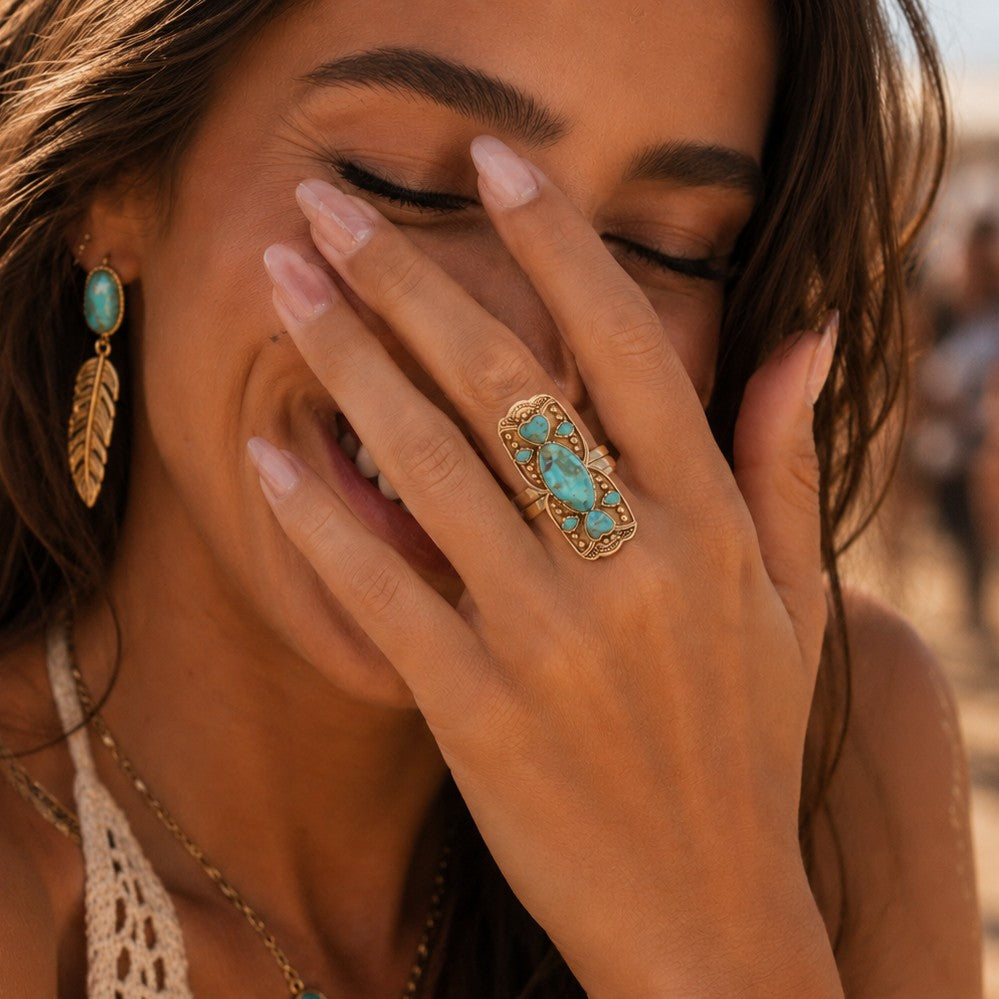 Woman with turquoise ring and earrings on a beach