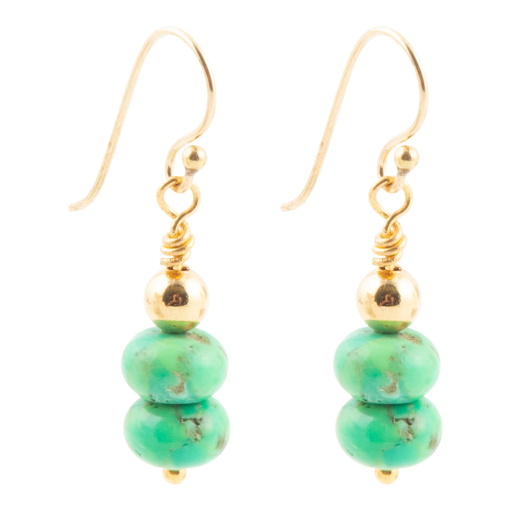 A pair of gold and turquoise drop earrings, featuring gold fishhook wires, a small gold bead, a wrapped gold spacer, and two stacked round turquoise beads at the bottom, shown on a plain white background.