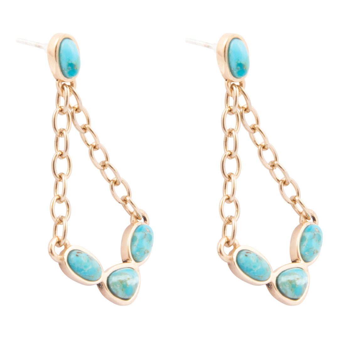 Pair of gold earrings with turquoise stones on a white background
