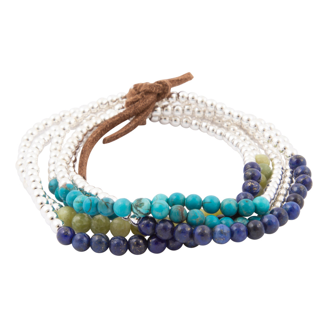 A set of multi-strand beaded bracelets with a brown leather tie closure. The bracelets feature silver-toned beads, turquoise blue beads, deep navy blue beads, and olive green beads, arranged in a circular stack on a plain white background.