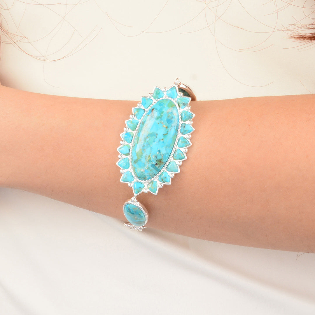 Turquoise bracelet on a person's wrist against a white background
