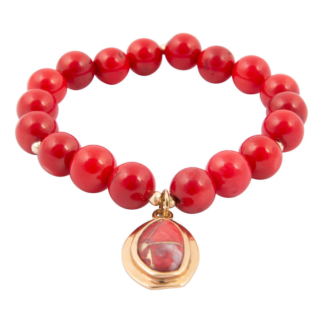 Red beaded bracelet with a gold and red pendant on a white background