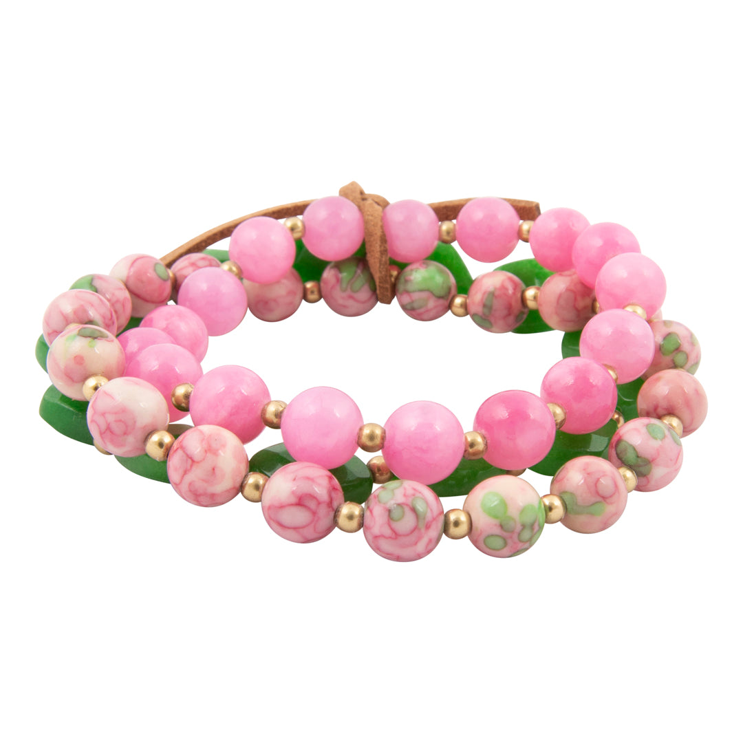 Beaded bracelet with pink and green beads on a white background