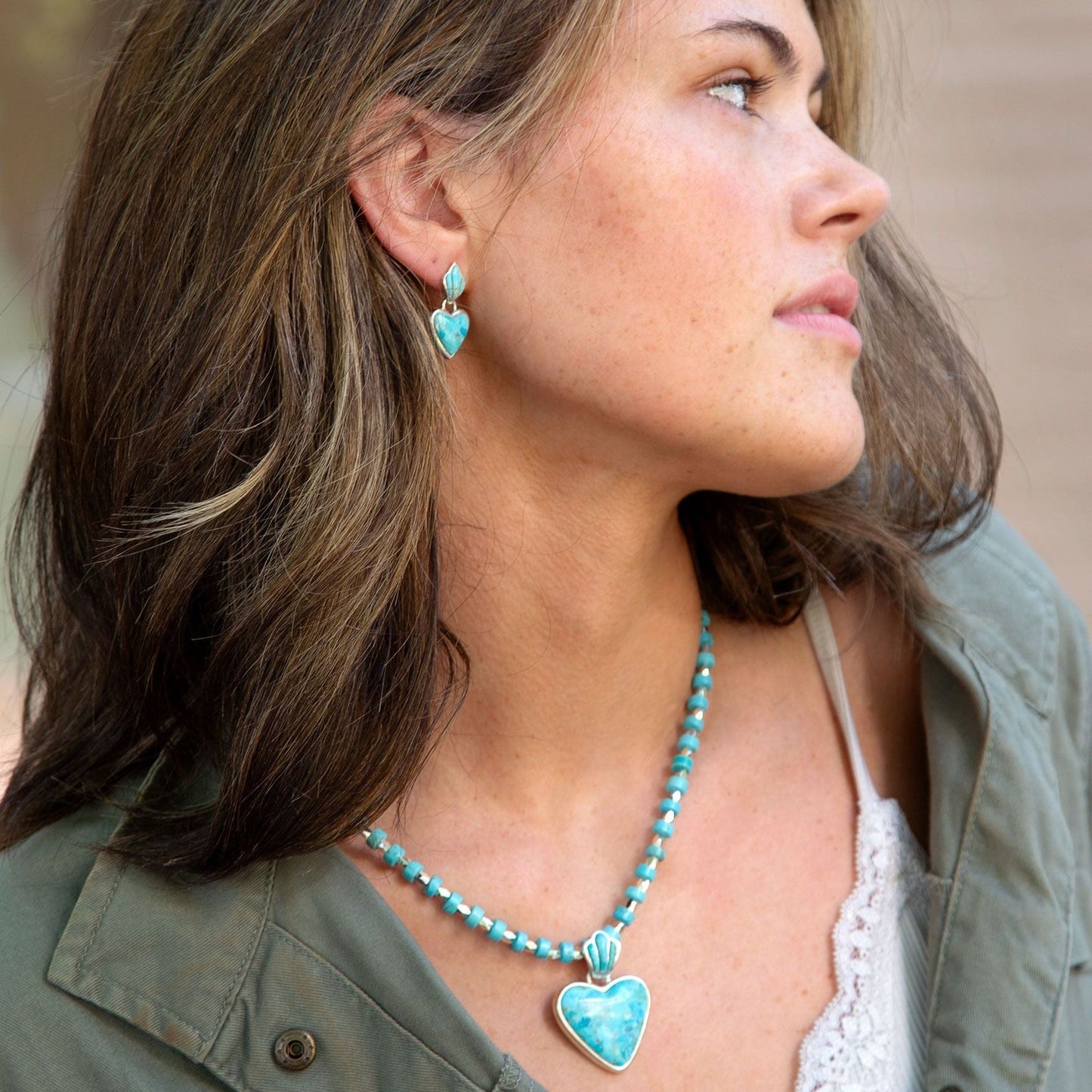 Woman wearing turquoise heart-shaped earrings and necklace