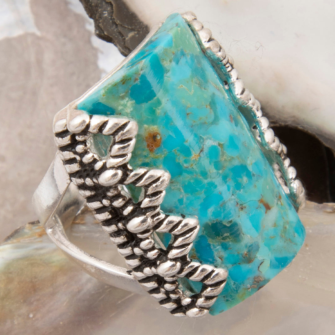 Silver ring with turquoise stone on a shell background