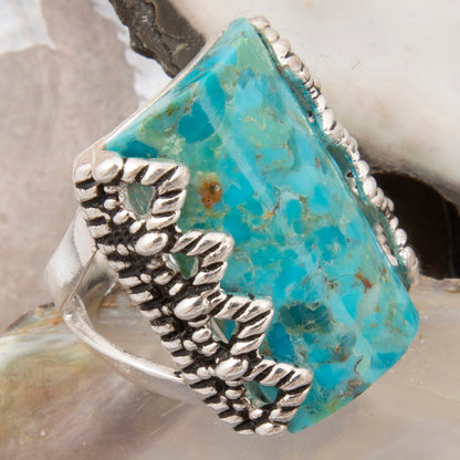 Silver ring with turquoise stone on a shell background