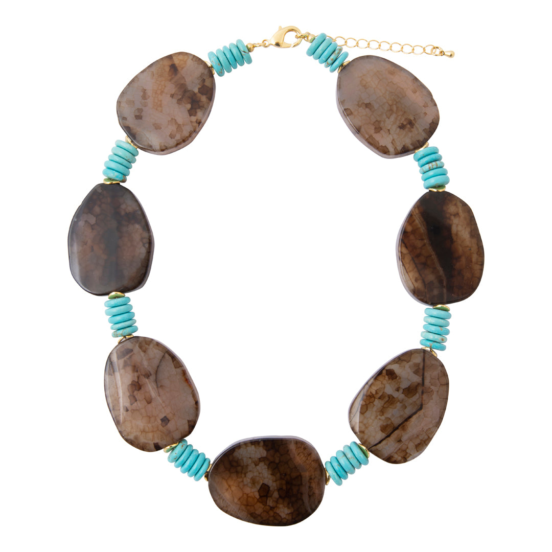 A statement necklace featuring seven polished brown stone beads with natural marbled patterns, separated by small turquoise spiral spacers and gold-toned hardware.