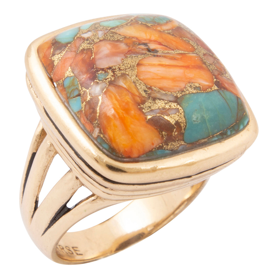 A gold ring featuring a large, square cushion-cut cabochon stone with a marbled pattern of orange, brown, and turquoise blue, accented with shimmering gold leaf inlay.