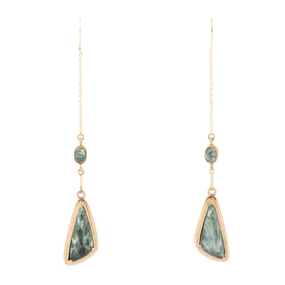 A pair of long drop earrings with gold-toned chains, small oval green stones, and larger irregular green stone pendants in gold-toned bezel settings, shown on a plain white background.