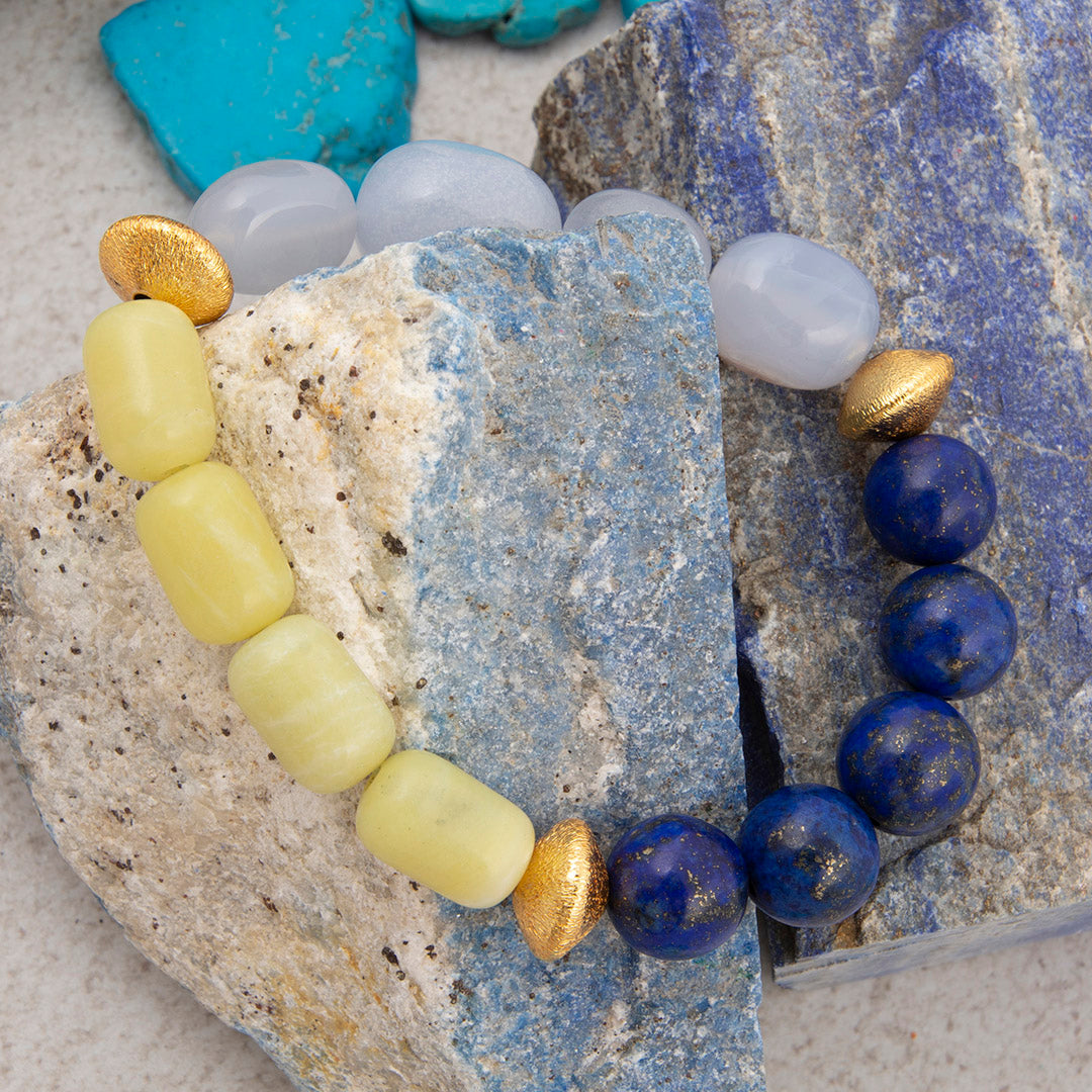 Bracelet with yellow, gold, and blue beads on a textured stone surface
