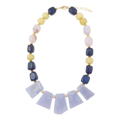A statement necklace featuring a row of light lavender quartz crystal fans at the center, flanked by alternating dark blue lapis lazuli, pale yellow citrine, and white marble round beads, accented with small gold spacers and a gold clasp.
