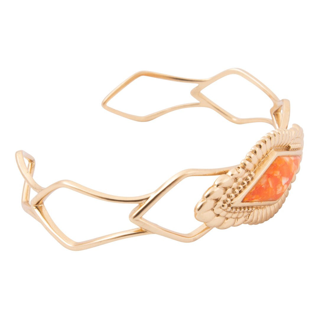 A gold-toned open cuff bracelet featuring a textured, woven-like gold segment on one end and a triangular orange stone inlay, set against a plain white background.