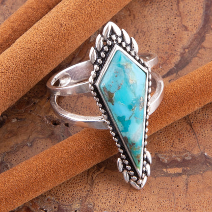 Silver ring with turquoise stone on a brown leather background