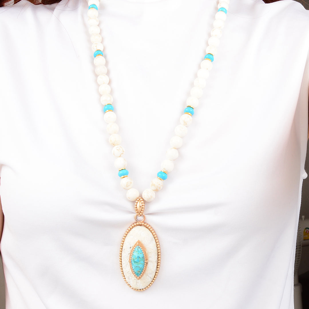 Necklace with white beads and a turquoise pendant on a white background
