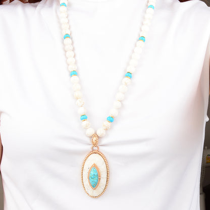 Necklace with white beads and a turquoise pendant on a white background