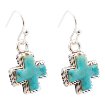 A pair of silver drop earrings featuring turquoise cross pendants, shown against a plain white background.