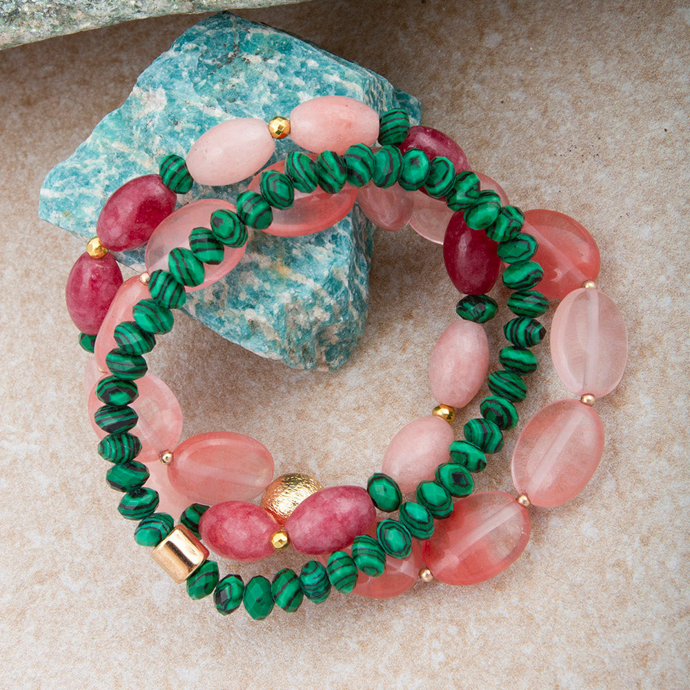 Beaded bracelet with pink and green beads on a textured surface