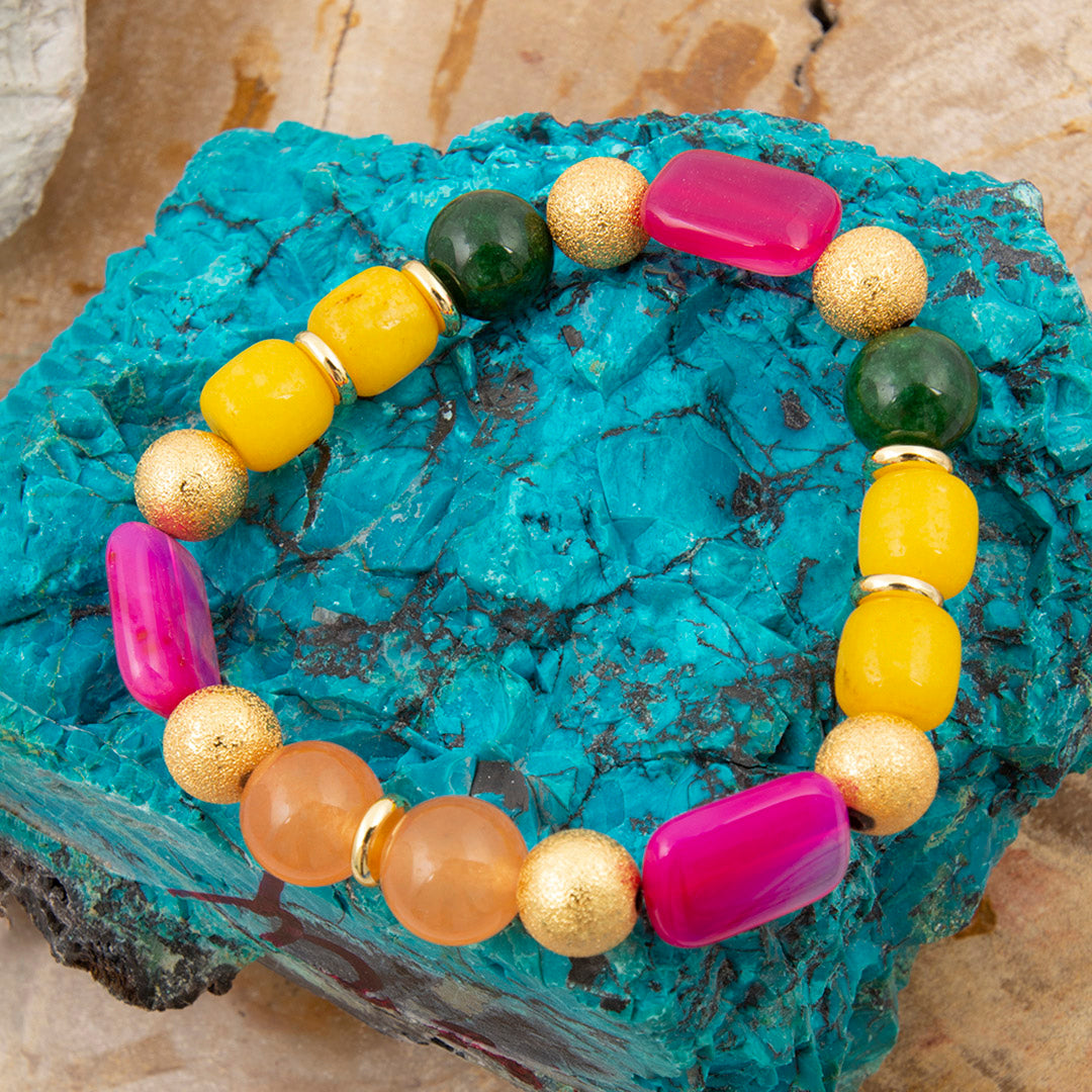Colorful beaded bracelet on a textured blue stone surface