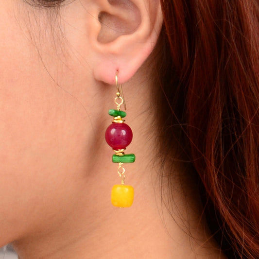 Close-up of a colorful earring worn by a person with red hair.