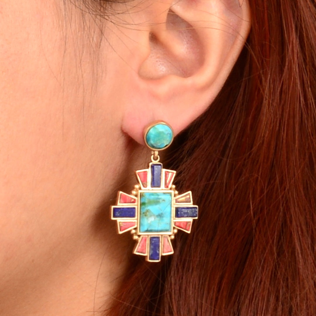 Close-up of a colorful earring worn by a person with red hair.