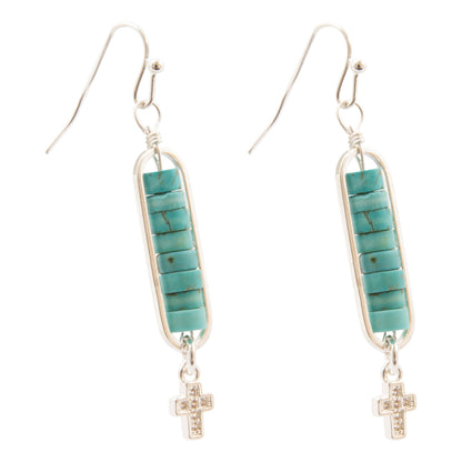 A pair of silver dangle earrings featuring rectangular turquoise stone inlays and small dangling cross charms, shown on a plain white background.