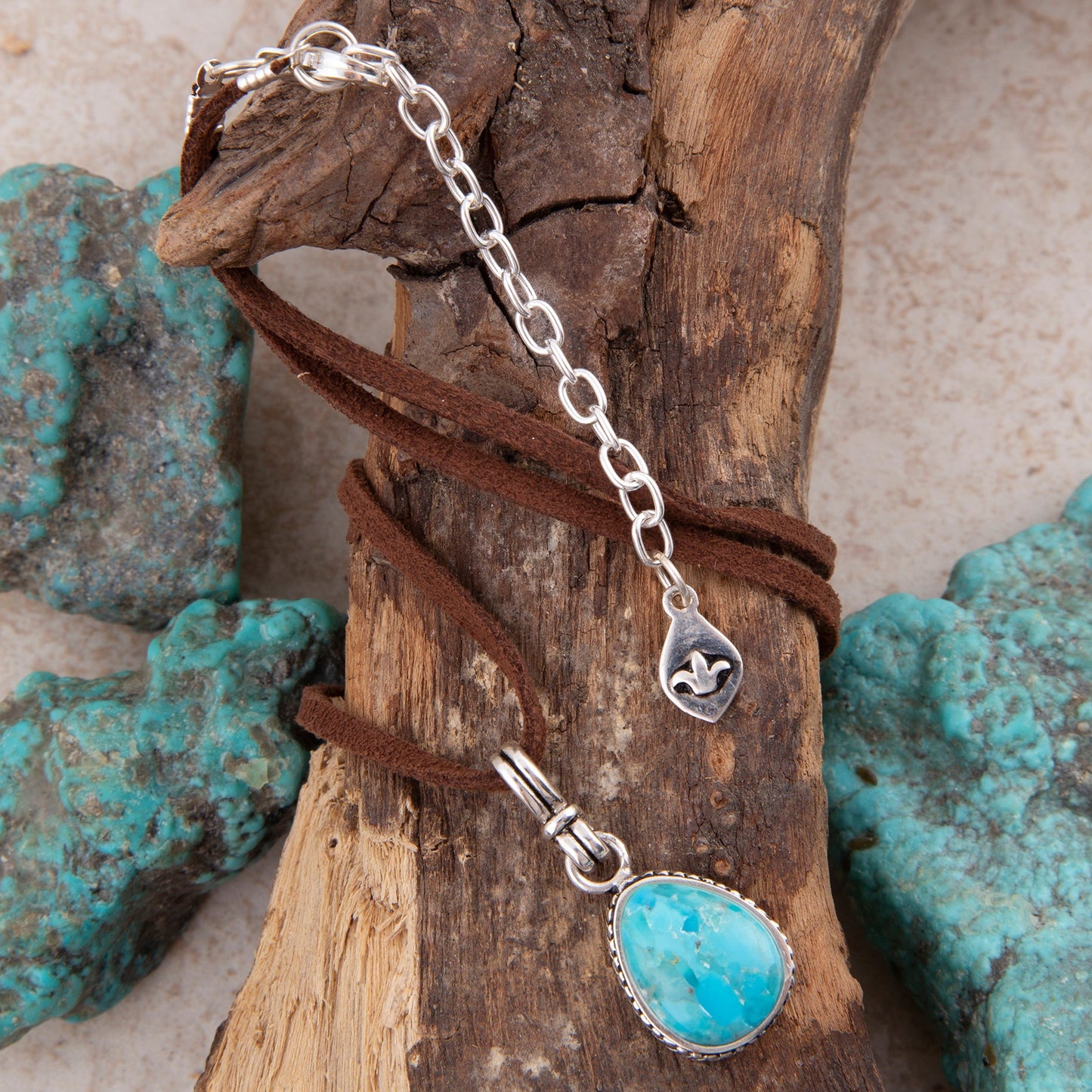 Turquoise pendant necklace on a wooden background with turquoise stones