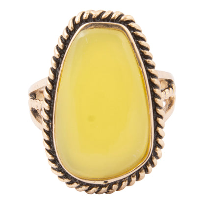 Ring with yellow stone and gold band on a white background
