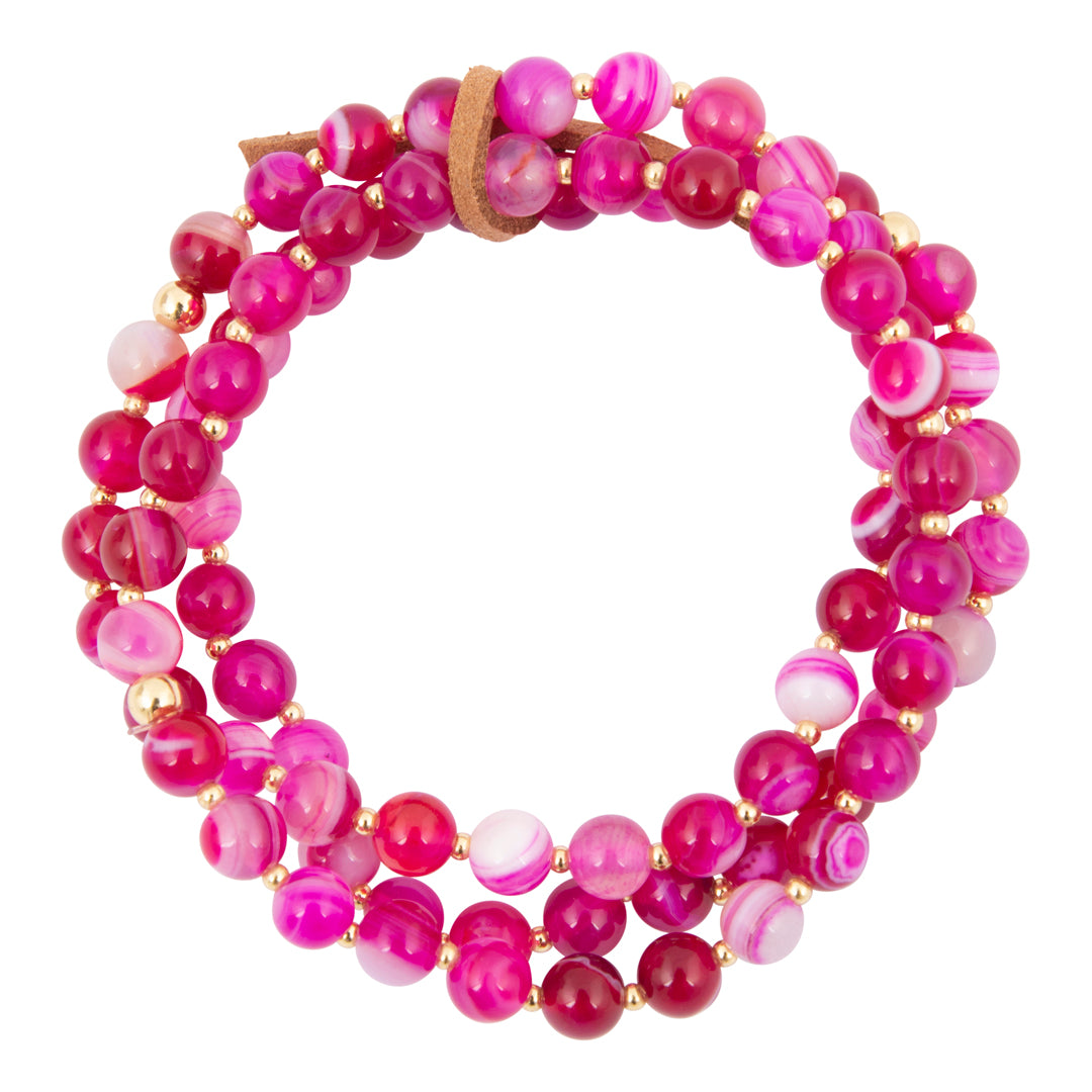 Multistrand bracelet with pink and purple beads on a white background
