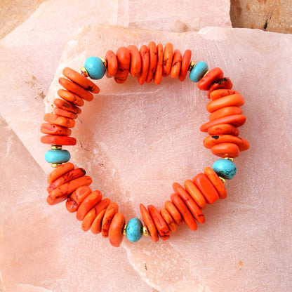 Bracelet with orange beads and turquoise accents on a textured surface