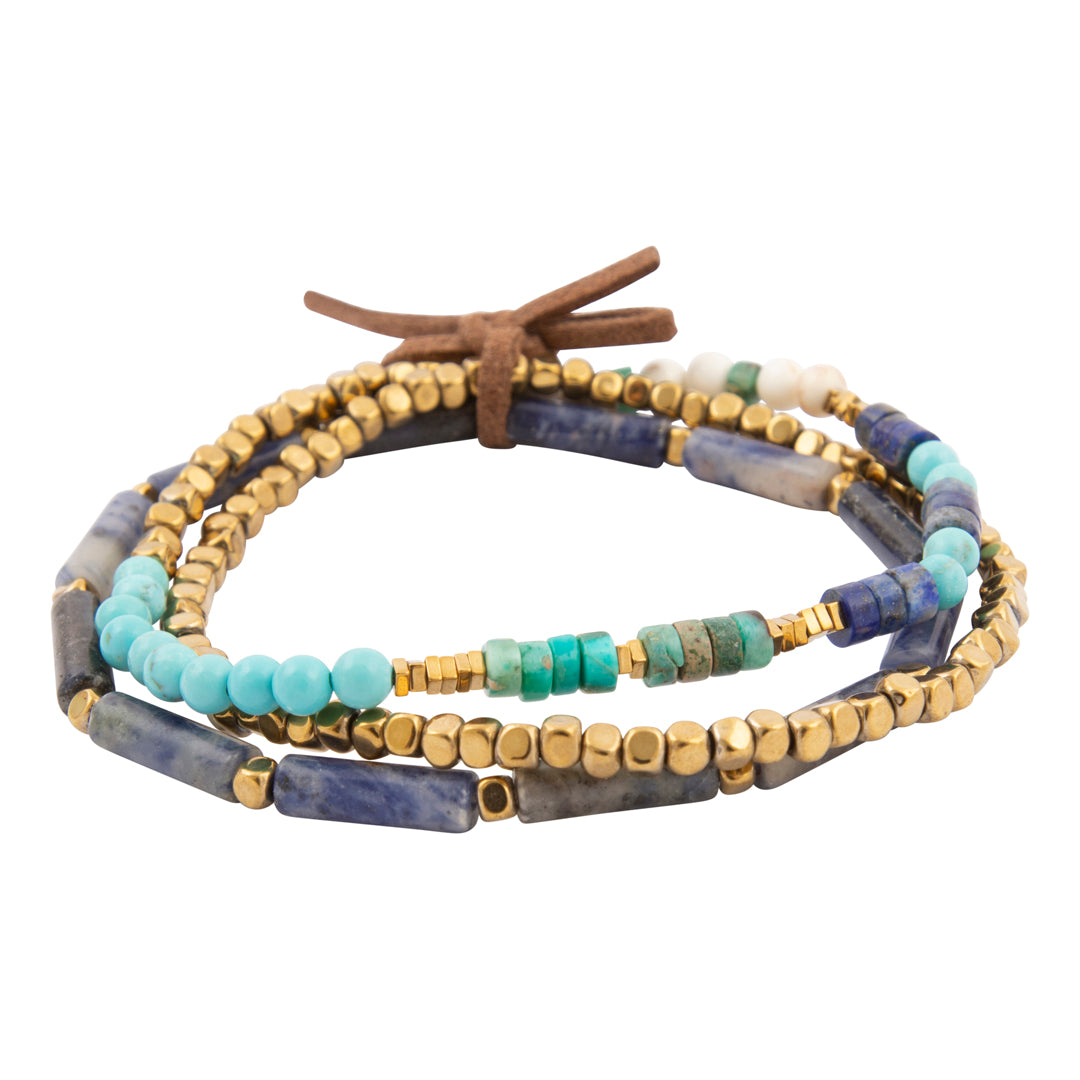 Multistrand beaded bracelet with blue, gold, and turquoise beads on a white background
