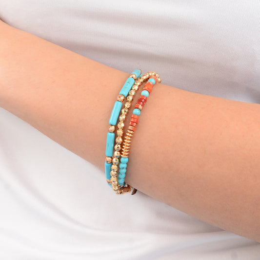 Multicolored beaded bracelets on a person's wrist against a white background