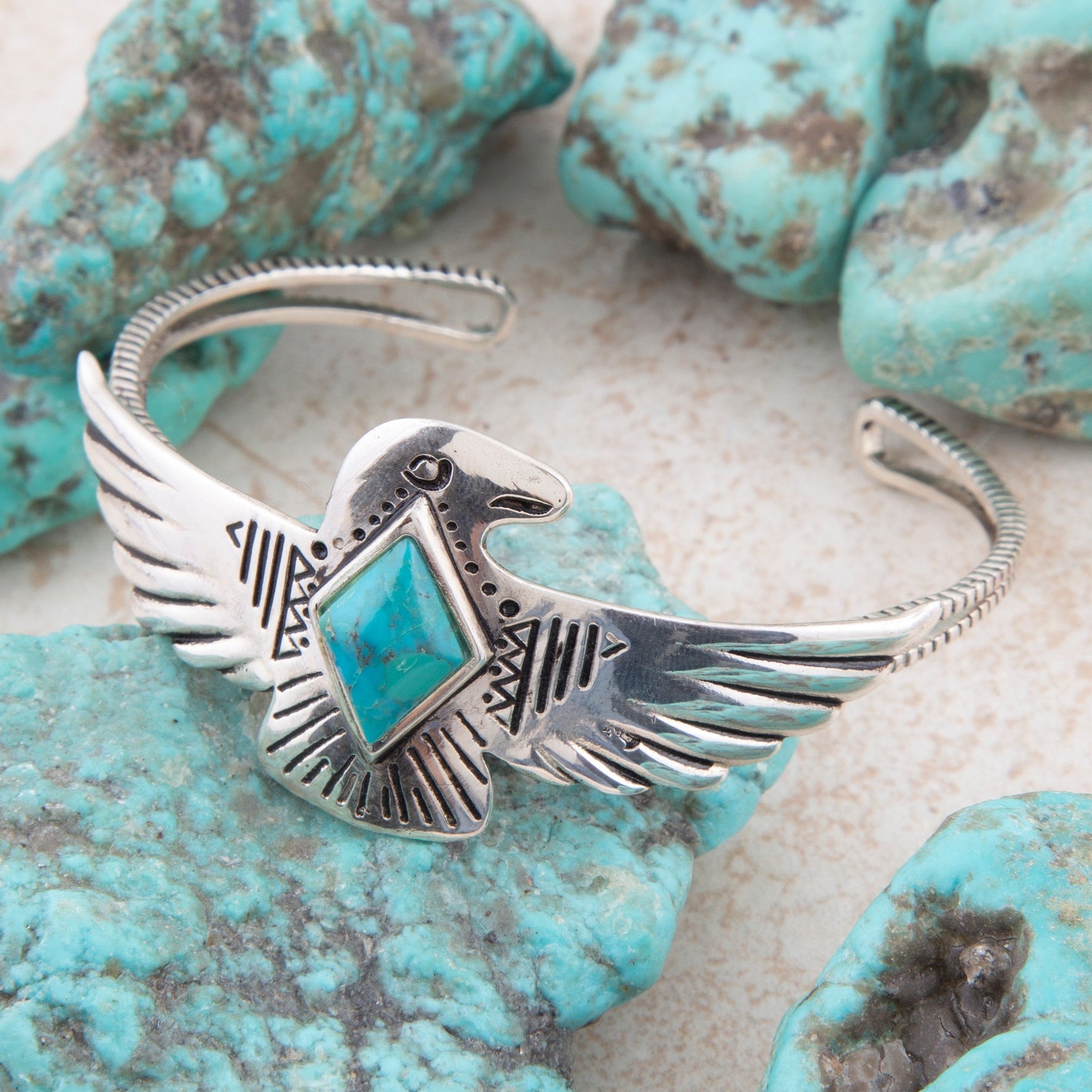 Silver bracelet with eagle design and turquoise stone on turquoise stones