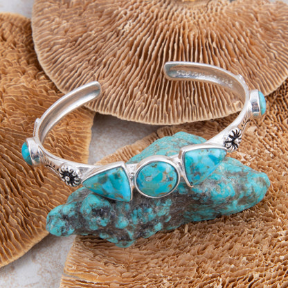 Silver bracelet with turquoise stones on a coral background