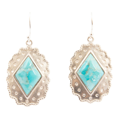 Pair of earrings with turquoise stones and silver frames on a white background