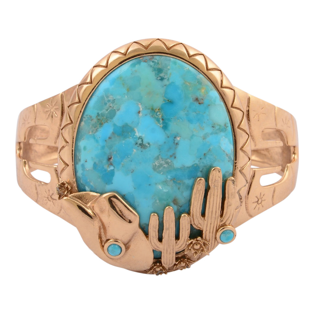 Gold ring with a large turquoise stone and smaller stones on a white background