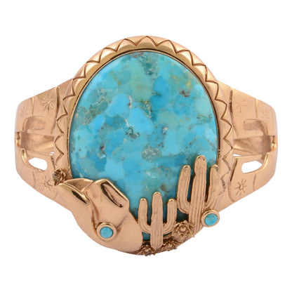 Gold ring with a large turquoise stone and smaller stones on a white background