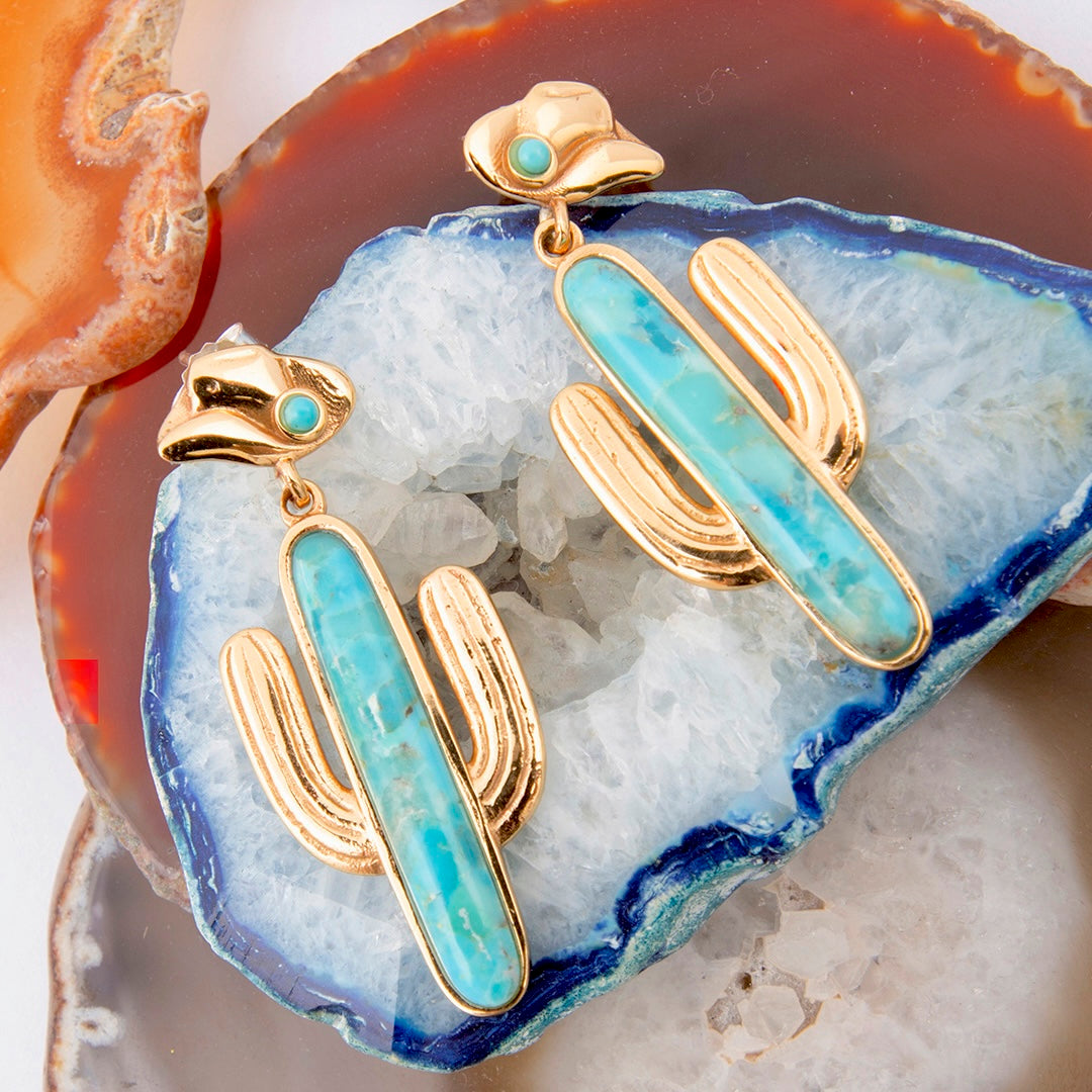 Gold and turquoise earrings on a geode background