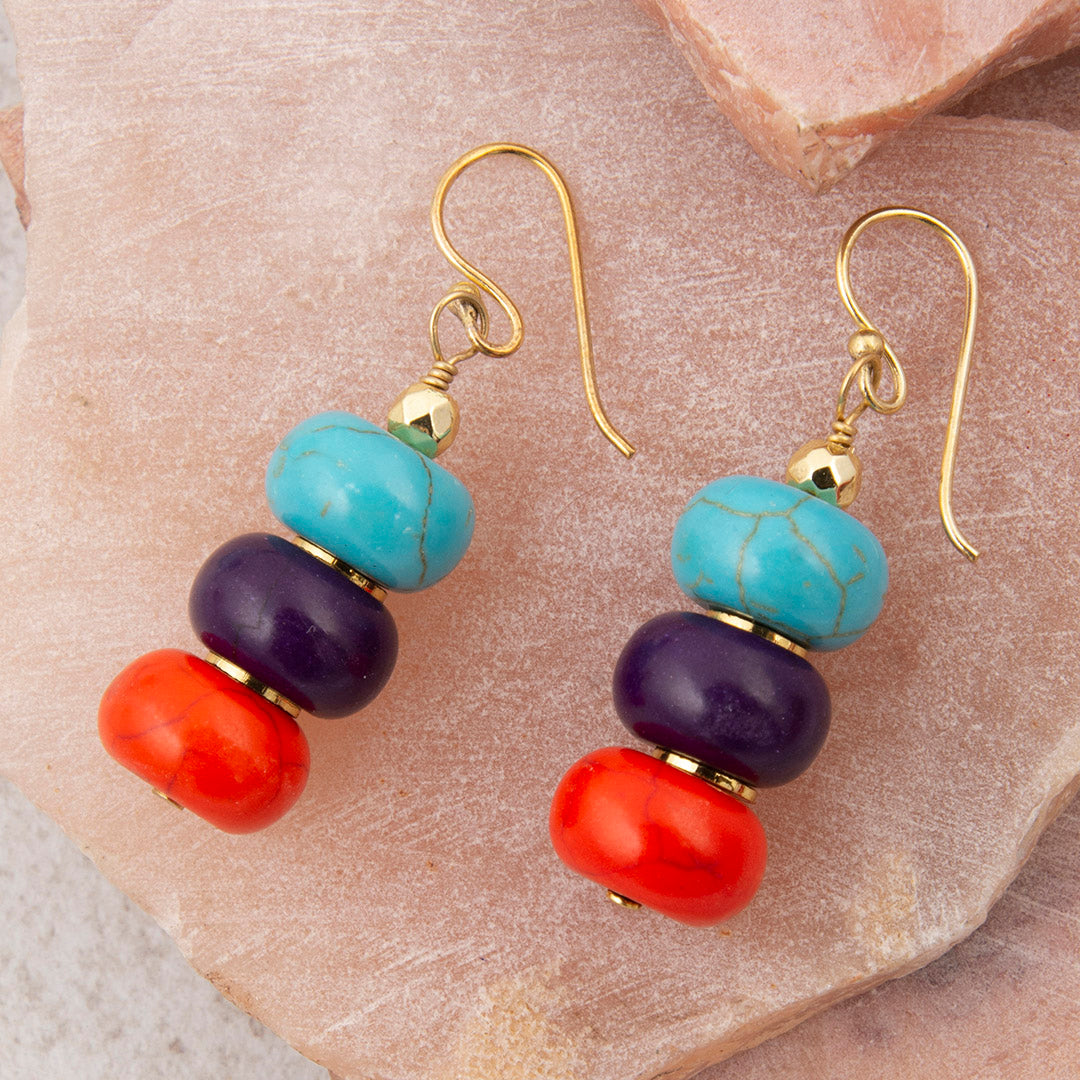 Colorful beaded earrings on a stone surface