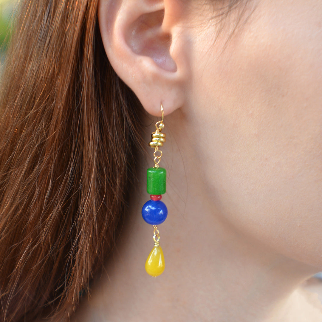 Close-up of an ear wearing colorful beaded earrings with a blurred background