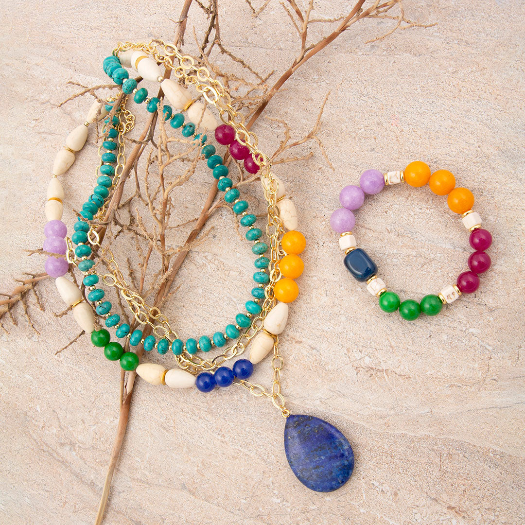 Colorful beaded bracelets on a textured surface with branches