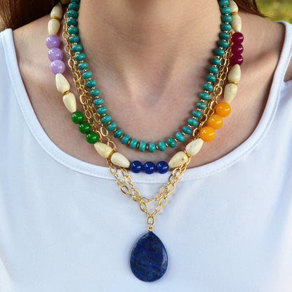 Colorful beaded necklace with a blue pendant on a white background