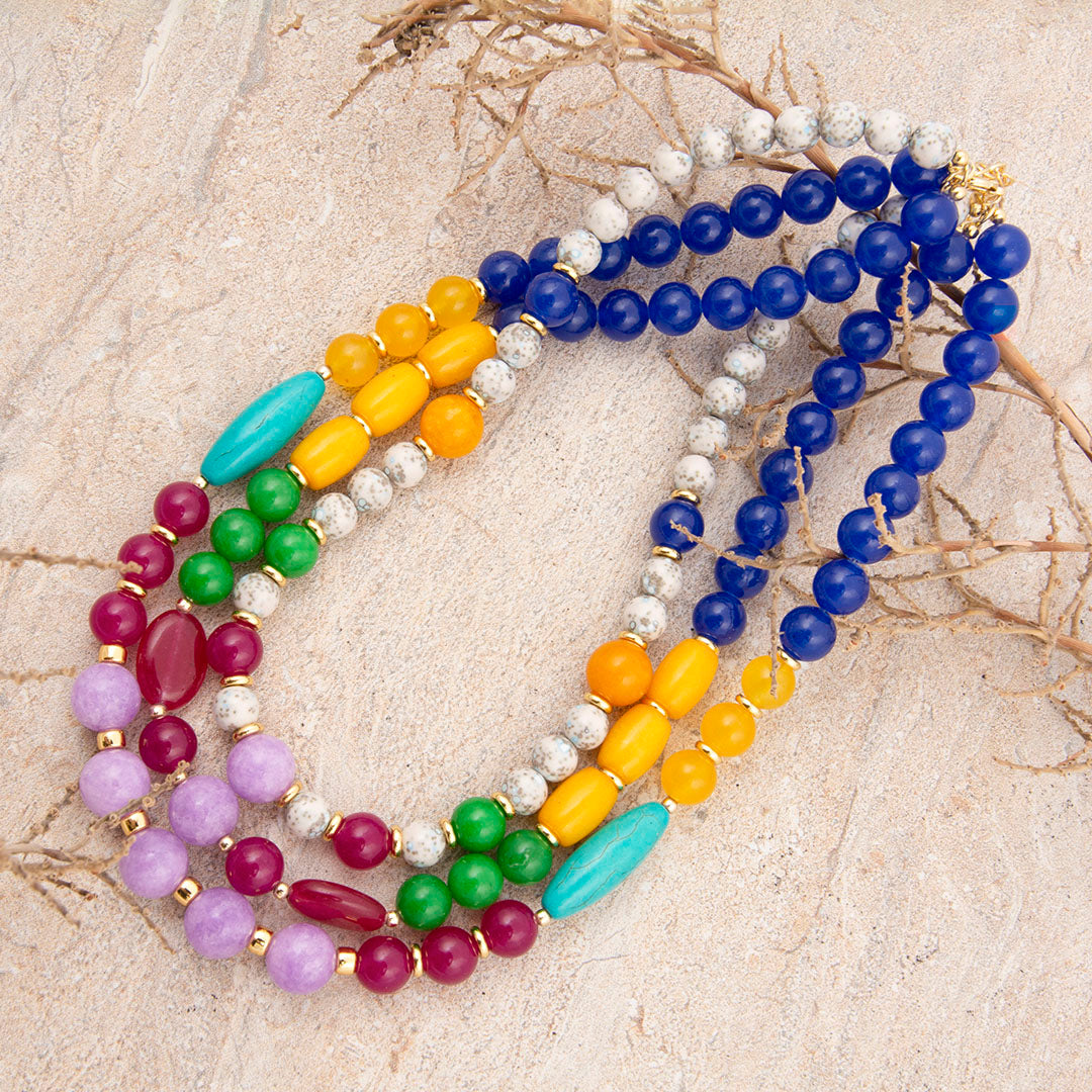 Colorful beaded necklaces on a textured surface