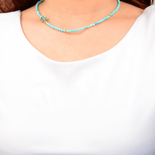 Turquoise beaded necklace worn by a person on a white background